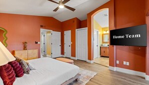 A bedroom with a bed, a ceiling fan, and a TV on the wall. - Sleeps 19 Pool Sport Court Putt Putt Gym (Mesa)
