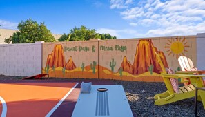 A basketball court with a mural of desert landscapes and cacti, a sun, and a chair. - Sleeps 19 Pool Sport Court Putt Putt Gym (Mesa)