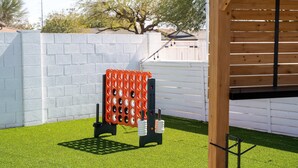 A fenced backyard with artificial grass, a wooden pergola, and a climbing structure. - The Ridge Family Pickleball Pool Hot Tub (Phoenix)