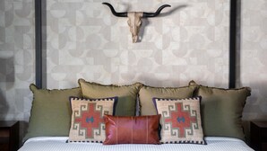A bed with a headboard, two decorative pillows, and a wall with a geometric pattern. - The Ridge Family Pickleball Pool Hot Tub (Phoenix)