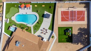 An aerial view of a property with a swimming pool, tennis court, and outdoor seating area. - The Ridge Family Pickleball Pool Hot Tub (Phoenix)