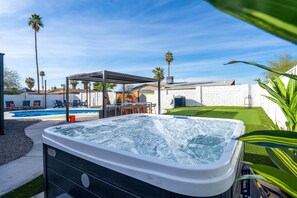 A hot tub with a pergola, a swimming pool, and palm trees. - Piece of Paradise Pool Games Fire Pit Hot tub (Glendale)