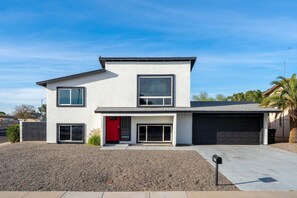 A modern two-story house with a garage, a red door, and a clear sky. - Piece of Paradise Pool Games Fire Pit Hot tub (Glendale)