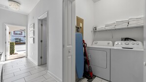 Ein Waschraum mit Waschmaschine, Trockner und gestapelten Handtüchern.