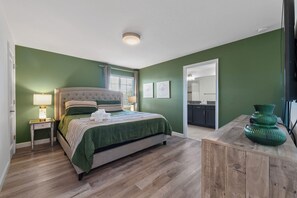 A bedroom with a bed, bedside tables, a dresser, and a mirror. - Resort Access Pool Sleeps 10 Themed Rooms (Davenport)