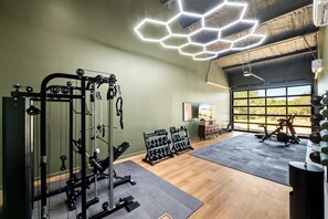 A gym with exercise equipment, a hexagonal light fixture, and large windows. - Birdie Creek Ranch - Private Golf Course Resort (Driftwood)