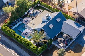 Ein Luftbild eines Anwesens mit Schwimmbad, Außenmöbeln und einer überdachten Terrasse.