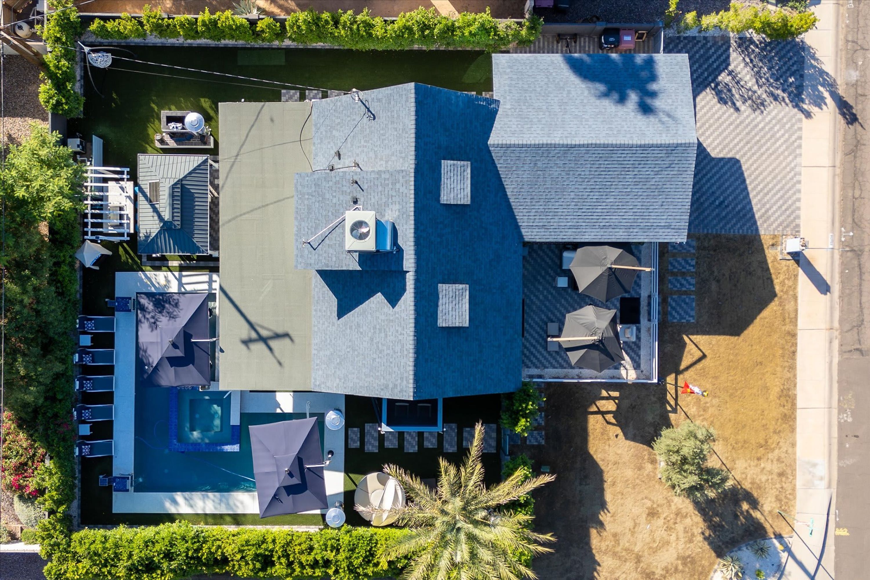 Vue aérienne d’une propriété dotée d’une piscine, d’un espace salon extérieur et d’un patio couvert.
