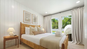 A bedroom with a large bed, a bedside table, a lamp, and a window with curtains. - Minutes to AMI Pool Game Room Sleeps 11 (Bradenton)