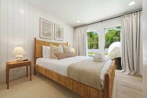 A bedroom with a large bed, a bedside table, a lamp, and a window with curtains. - Minutes to AMI Pool Game Room Sleeps 11 (Bradenton)