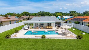 A residential property with a swimming pool, a covered patio, and a fenced backyard. - Minutes to AMI Pool Game Room Sleeps 11 (Bradenton)