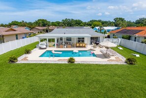A residential property with a swimming pool, a covered patio, and a fenced backyard. - Minutes to AMI Pool Game Room Sleeps 11 (Bradenton)