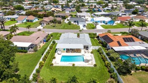 A residential area with houses, a swimming pool, and solar panels. - Minutes to AMI Pool Game Room Sleeps 11 (Bradenton)