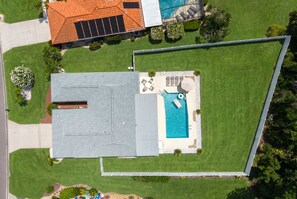 A residential property with a swimming pool, a covered patio, and a fenced yard. - Minutes to AMI Pool Game Room Sleeps 11 (Bradenton)