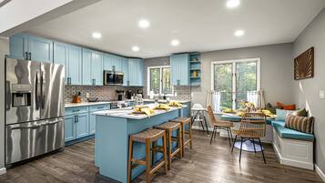 A modern kitchen with a central island, stainless steel appliances, and light blue cabinetry.