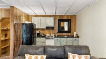 A modern kitchen with wooden cabinets, a black refrigerator, and a stove.