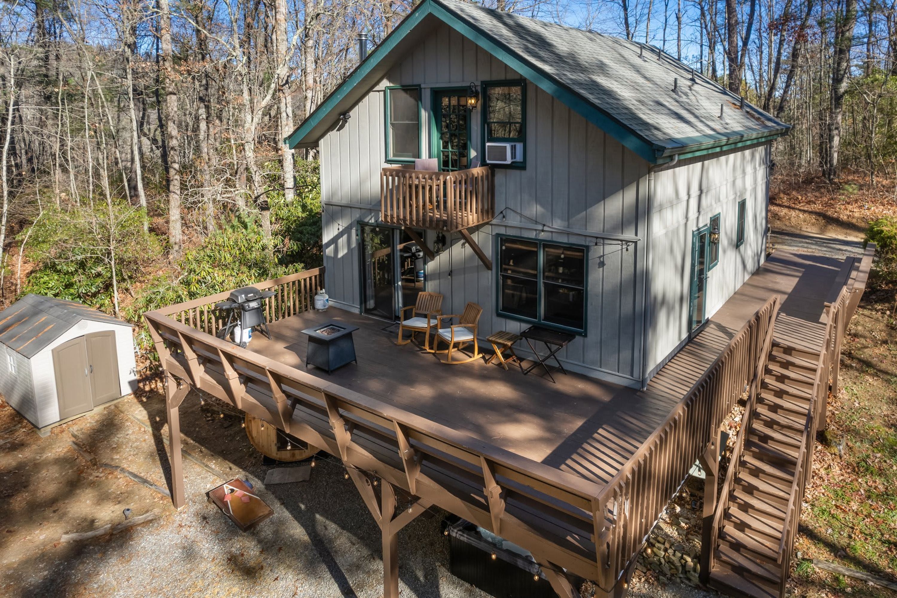 Une cabane avec une terrasse, un foyer extérieur et des sièges pour profiter de l’extérieur.