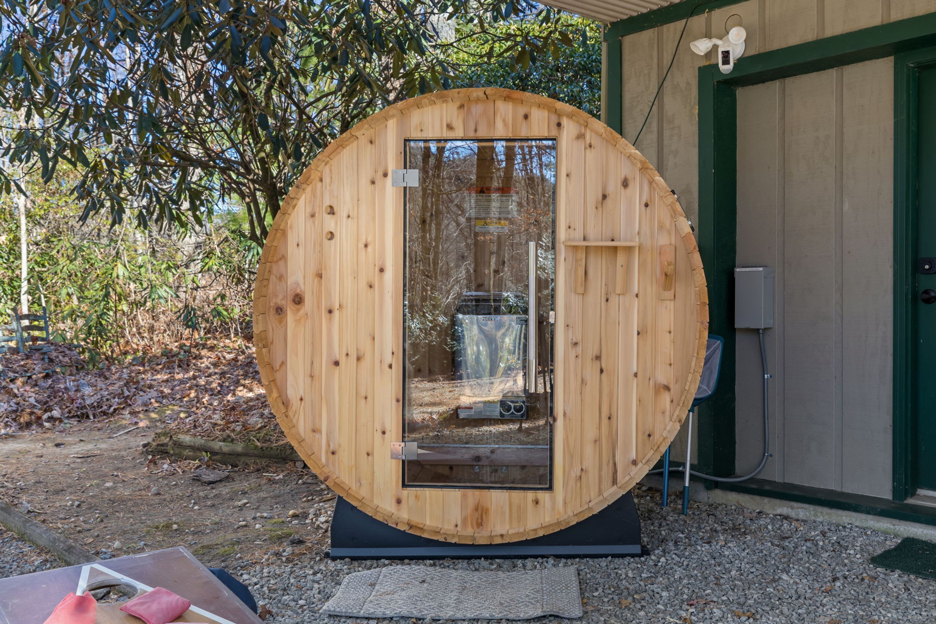 A circular wooden structure with a door, a small window, and a doorbell.
