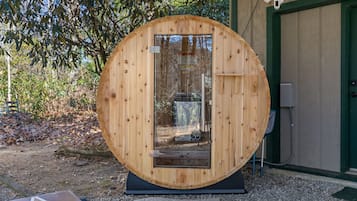 A circular wooden structure with a door, a small window, and a doorbell.