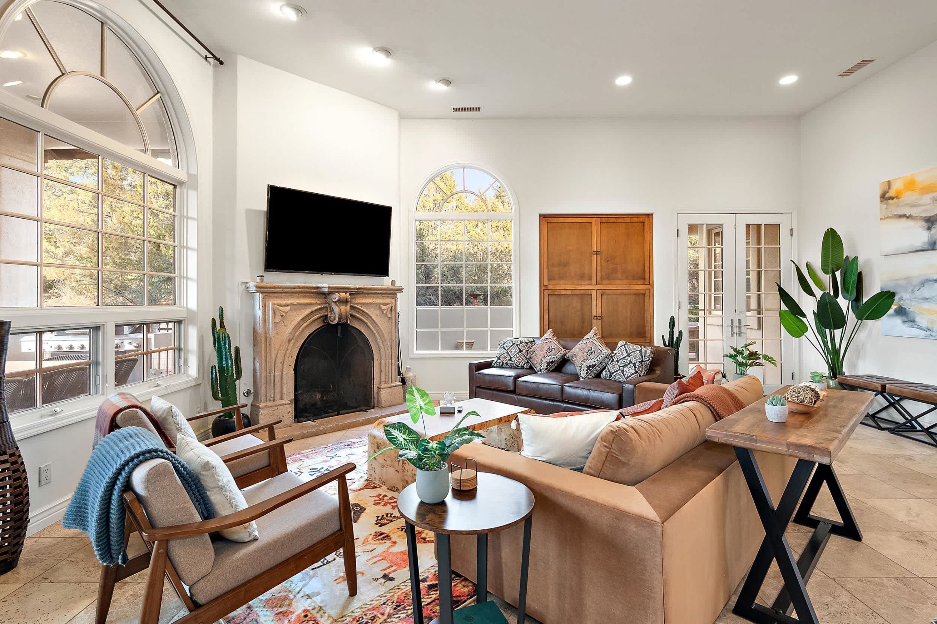 A spacious living room with a fireplace, comfortable seating, and large windows.