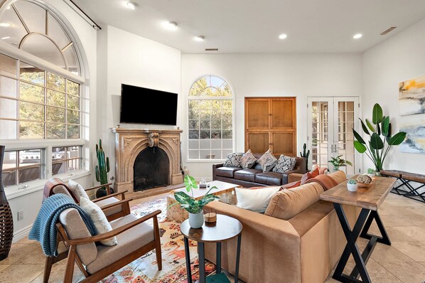 A spacious living room with a fireplace, comfortable seating, and large windows. - NEW Heated Pool Outdoor Fun Hottub Games More (Sedona)