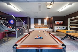 A pool table with a billiard cue, a red chair, and a billiard rack with balls. - NEW Heated Pool Outdoor Fun Hottub Games More (Sedona)