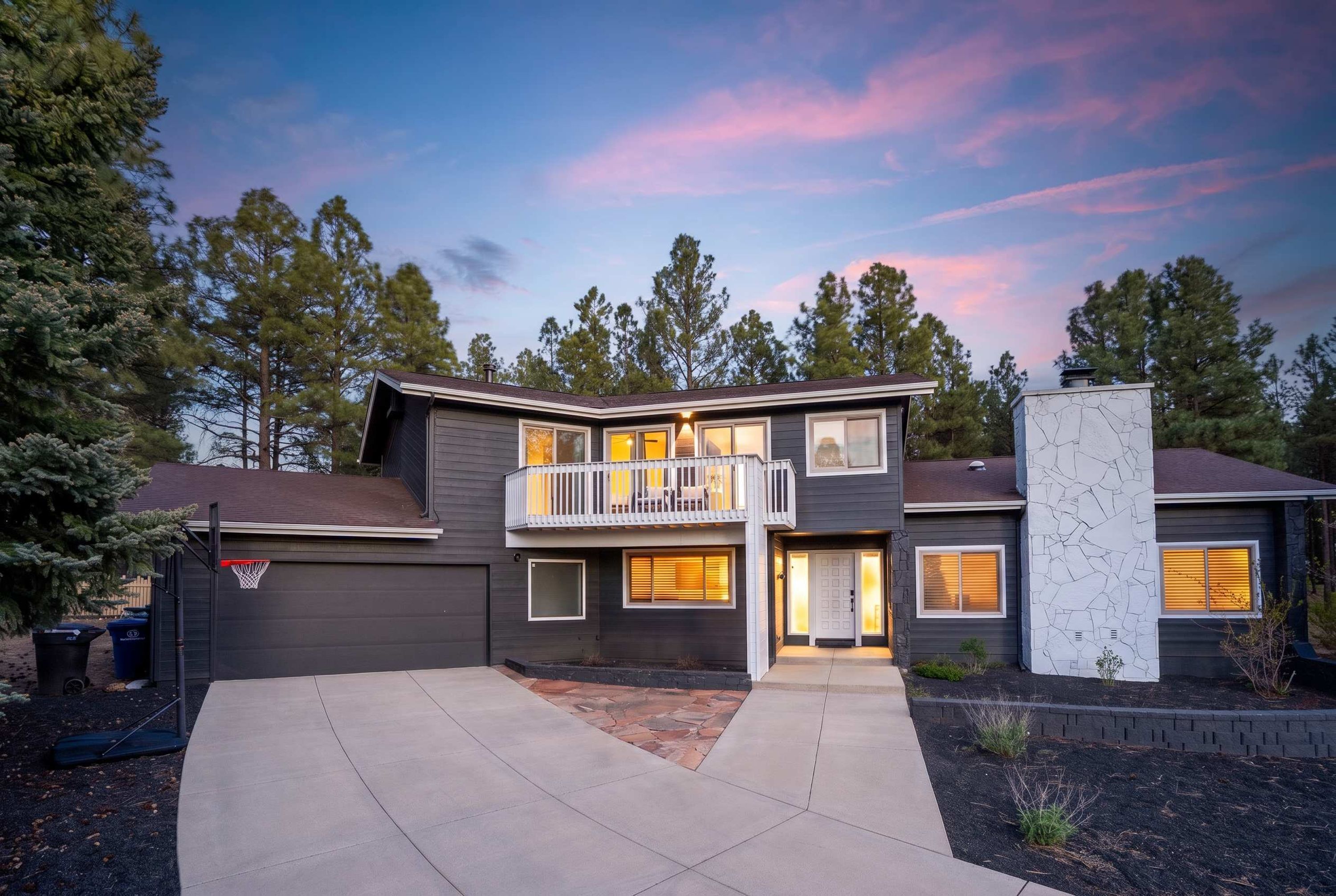 A two-story house with a balcony, a garage, and a driveway.