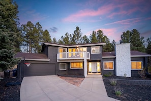 A two-story house with a balcony, a garage, and a driveway. - Family-friendly Getaway Hot Tub View EV Chrg (Flagstaff)