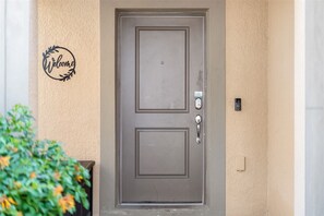 Eine Tür mit Tastatur-Schließmechanismus und einem an der Wand montierten Gegensprechanlage.