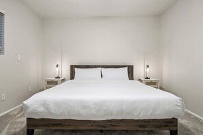 A bedroom with a wooden headboard, a white bedspread, two bedside lamps, and a carpeted floor. - 360 Mtn Views Fireplace Patio Bird Watching (Tucson)