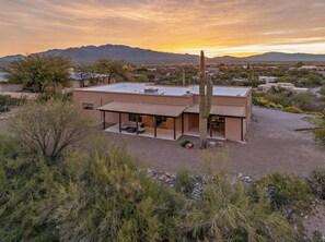 A modern two-story house with a flat roof, a covered patio area, and a large cactus in the foreground. - 360 Mtn Views Fireplace Patio Bird Watching (Tucson)