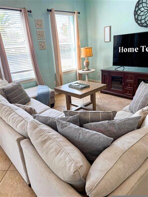 A living room with a sofa, a coffee table, a TV, and a lamp. - Mins From Beach Sleeps 17 Outdoor Seating (Destin)