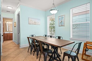 A dining area with a long table and chairs, a ceiling light, and artwork on the walls. - Mins From Beach Sleeps 17 Outdoor Seating (Destin)