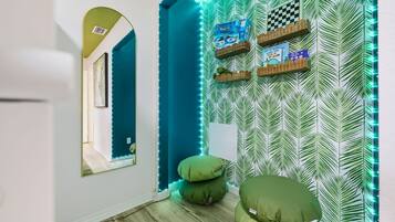 A hallway with a mirrored wall, a checkered board game, and a wall with a leaf pattern.
