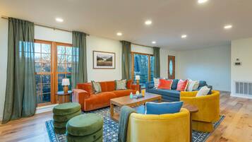 A spacious living room with a sofa set, a coffee table, and a rug.