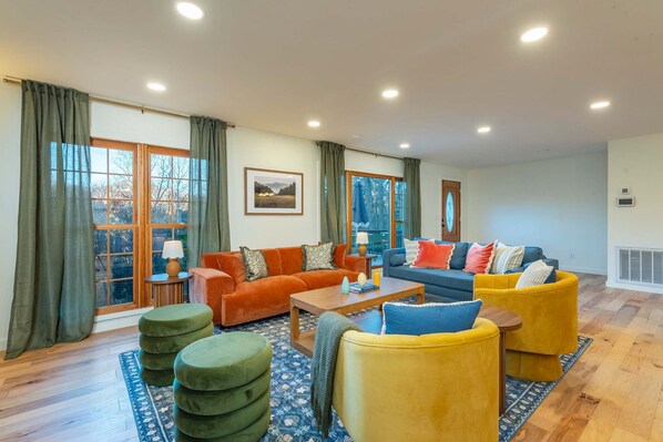 A spacious living room with a sofa set, a coffee table, and a rug. - Expansive Deck Sleeps 16 Hot Tub Game Room (Fairview)