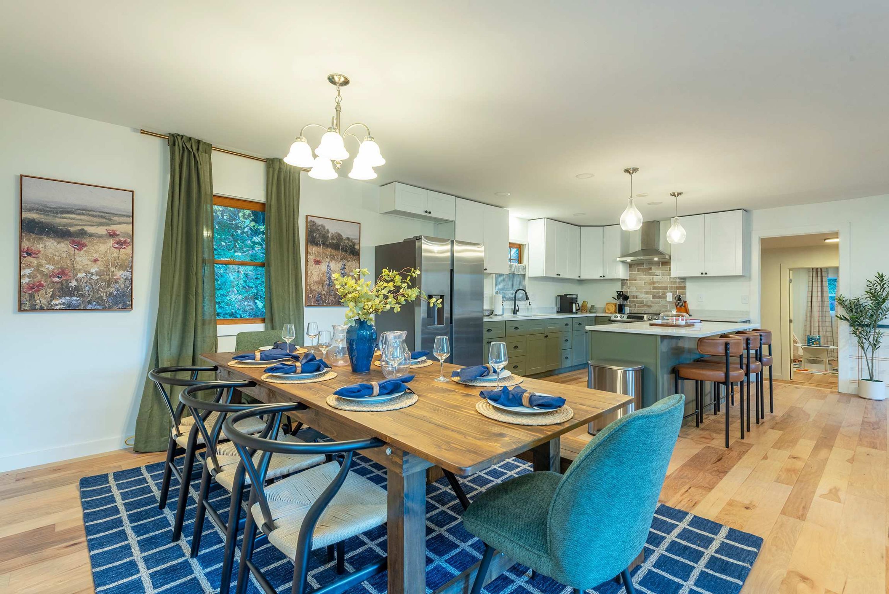 A modern kitchen with white cabinets, a central island, and pendant lighting.