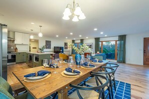 A modern kitchen with a dining area set for a meal. - Expansive Deck Sleeps 16 Hot Tub Game Room (Fairview)