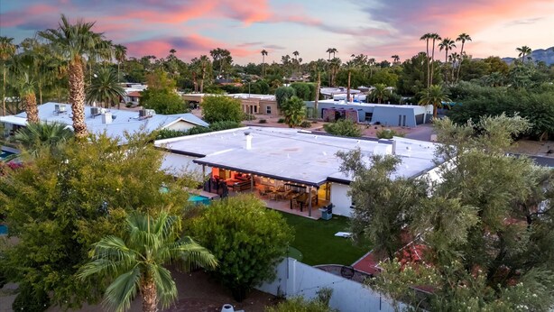 A residential area with multiple houses, some with flat roofs and others with sloped roofs, surrounded by palm trees and greenery. - The Sunkiss Pickleball Heated Pool Hot Tub (Scottsdale)