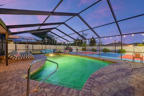 An outdoor swimming pool with a covered area, a basketball court, and lounge chairs. - Suncourt Retreat Sports Court Pool Hot Tub (Bradenton)