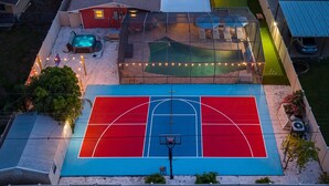 A basketball court with a pool and hot tub in the background. - Suncourt Retreat Sports Court Pool Hot Tub (Bradenton)