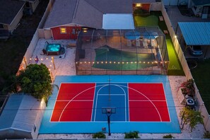 A basketball court with a pool and hot tub in the background. - Suncourt Retreat Sports Court Pool Hot Tub (Bradenton)
