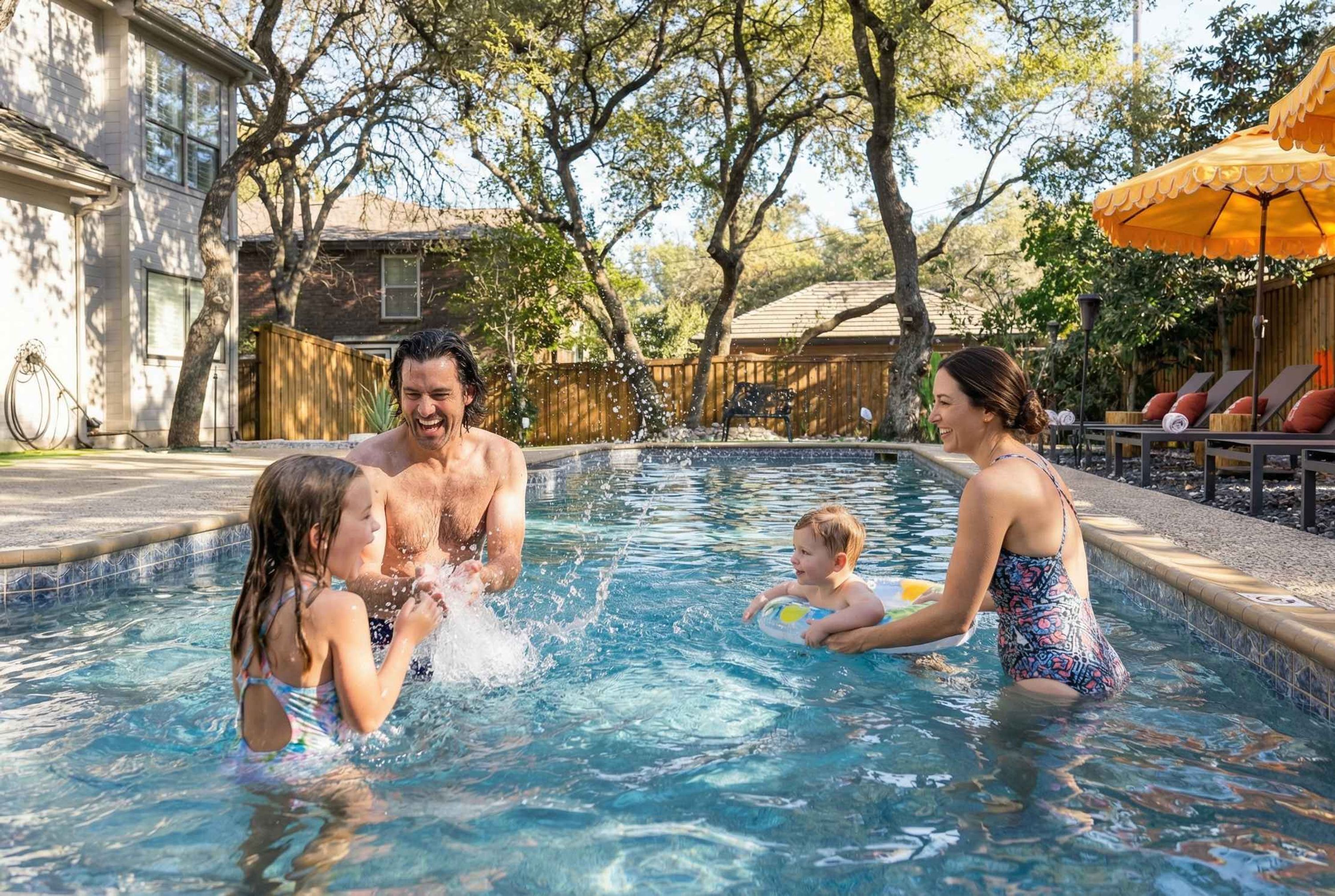 A swimming pool with a wooden deck, lounge chairs, and a fence in the background.