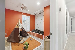 A child's playroom with a tent, climbing wall, and a ceiling fan. - Ultimate Backyard Pool Game Room Kid s Room (San Antonio)