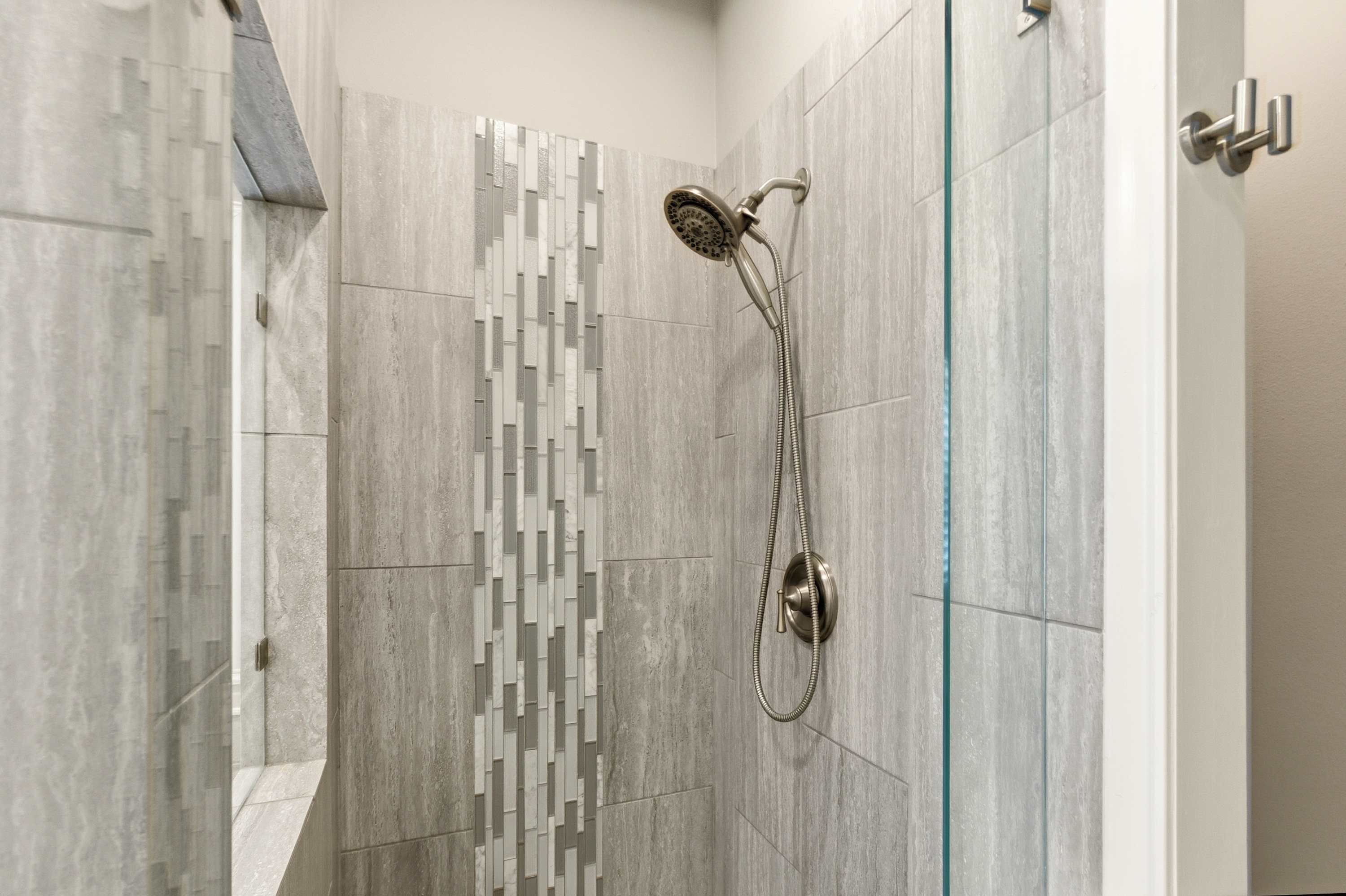 A modern shower area with a rain shower head and a handheld shower attachment.