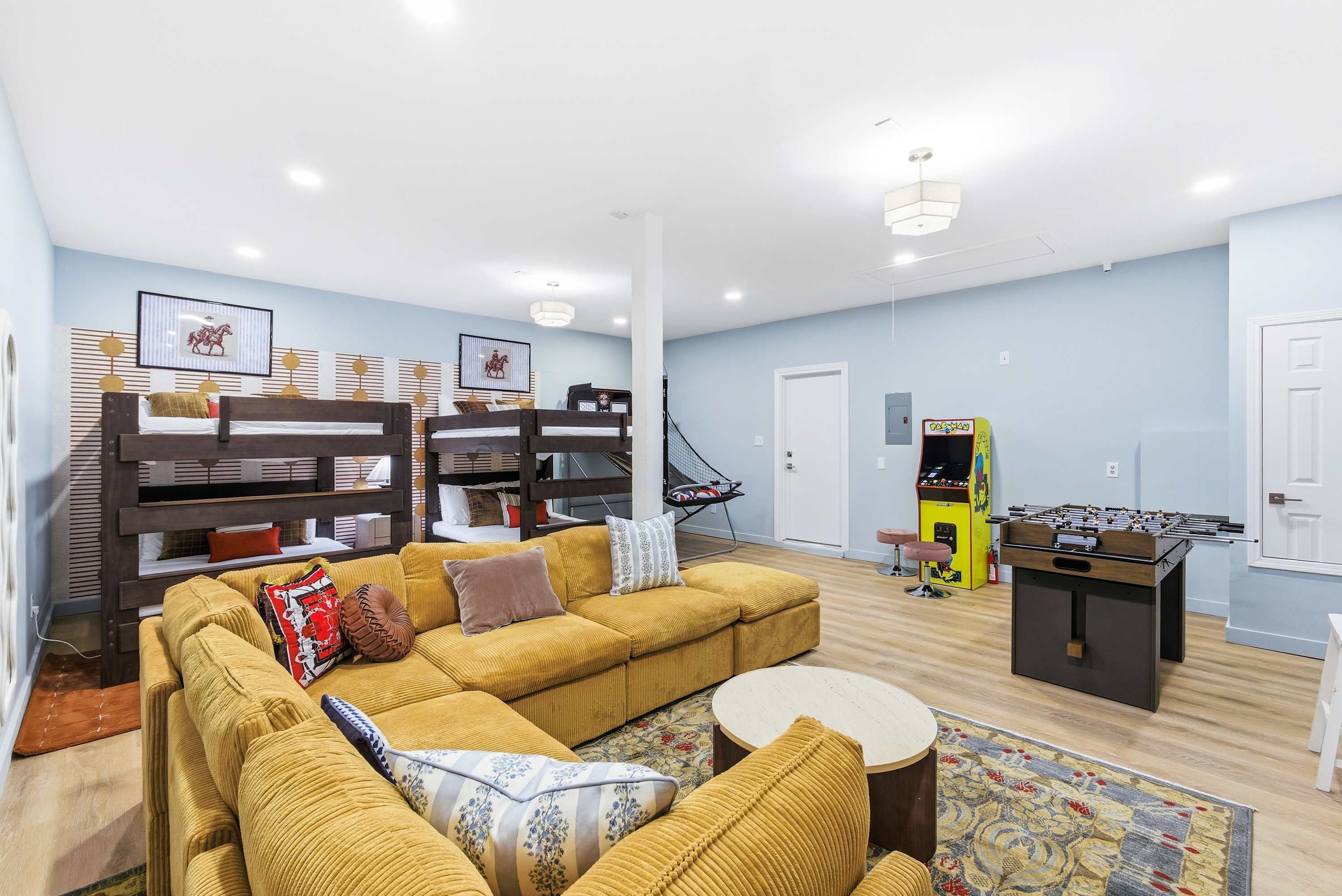 A living room with a sofa, a foosball table, and a bookshelf.