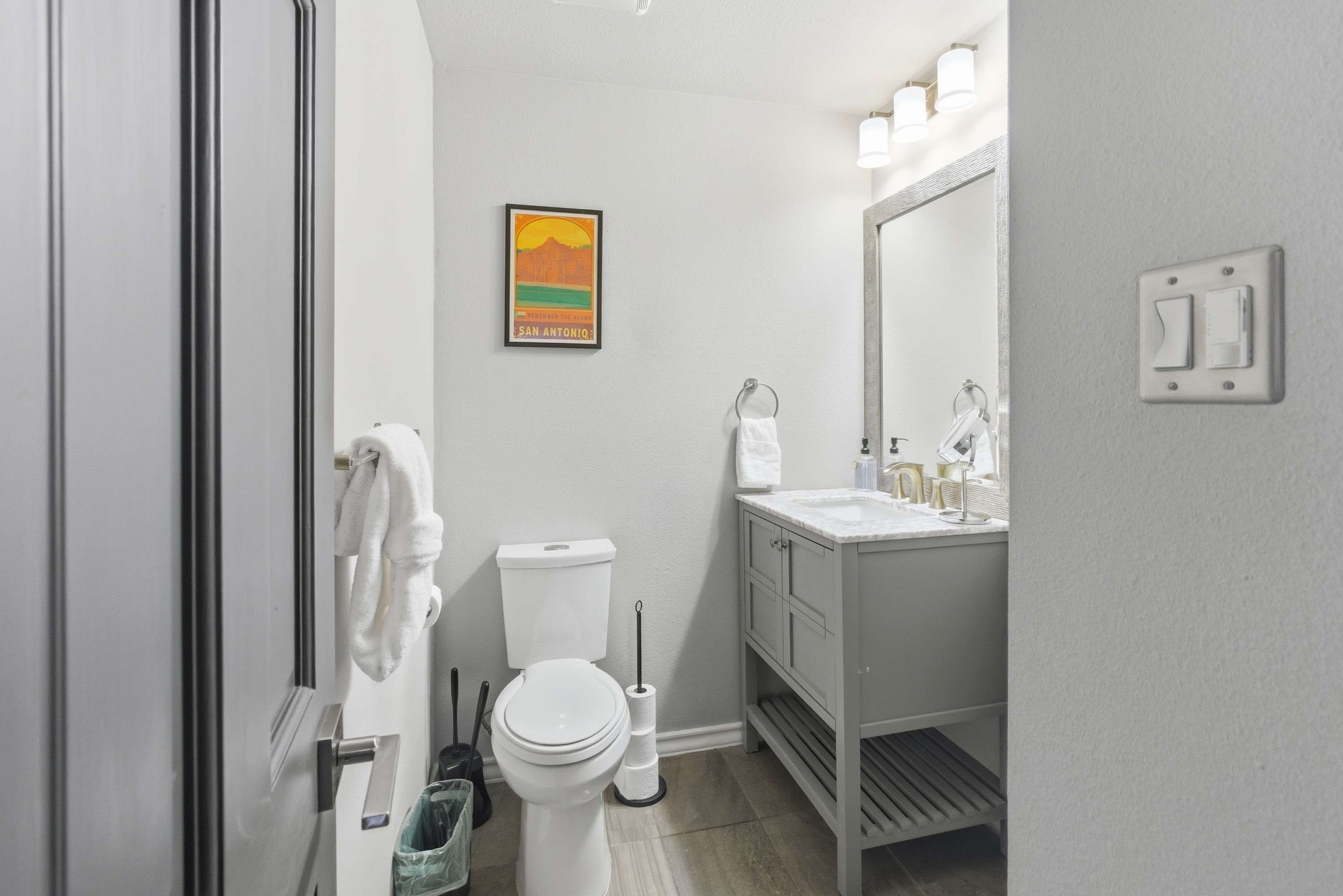 Baño con inodoro, lavamanos y perchero.
