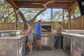 An outdoor kitchen with a grill, a sink, and a countertop. - Ultimate Backyard Pool Game Room Kid s Room (San Antonio)