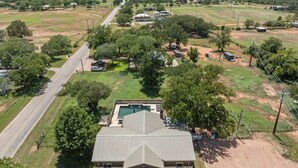 Una casa gran amb un jardí ample al davant, una piscina i un camí al costat.