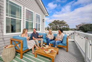 A group of people sitting on a porch with a table of food and drinks. - Golf Sim Theater Games Walk to Beach Sleeps 28 (North Myrtle Beach)